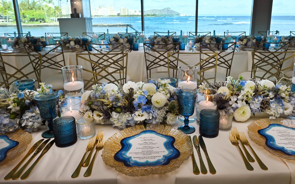 A beautifully arranged reception table adorned with blue and white flowers.